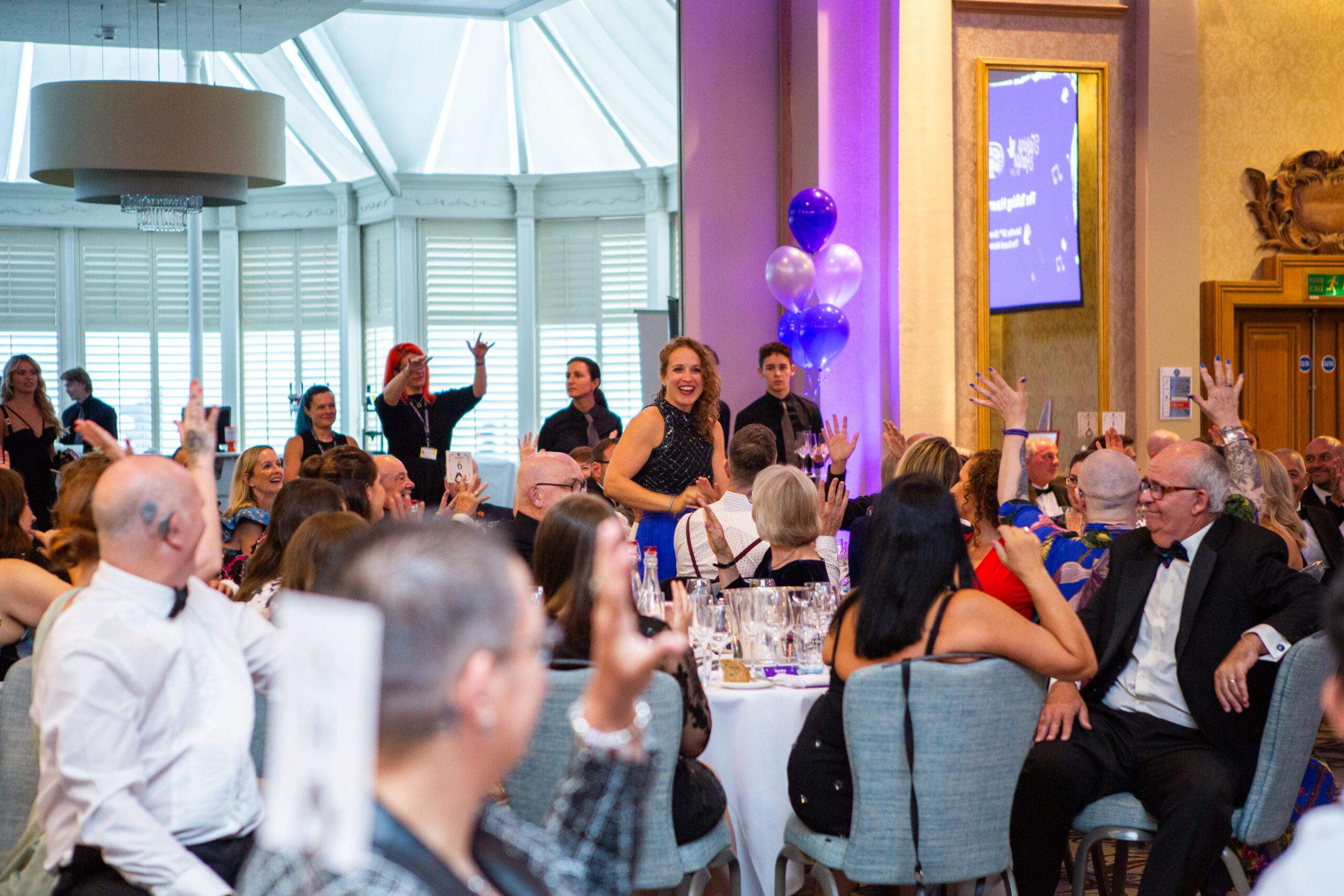 Gala guests cheering whilst sat at their tables