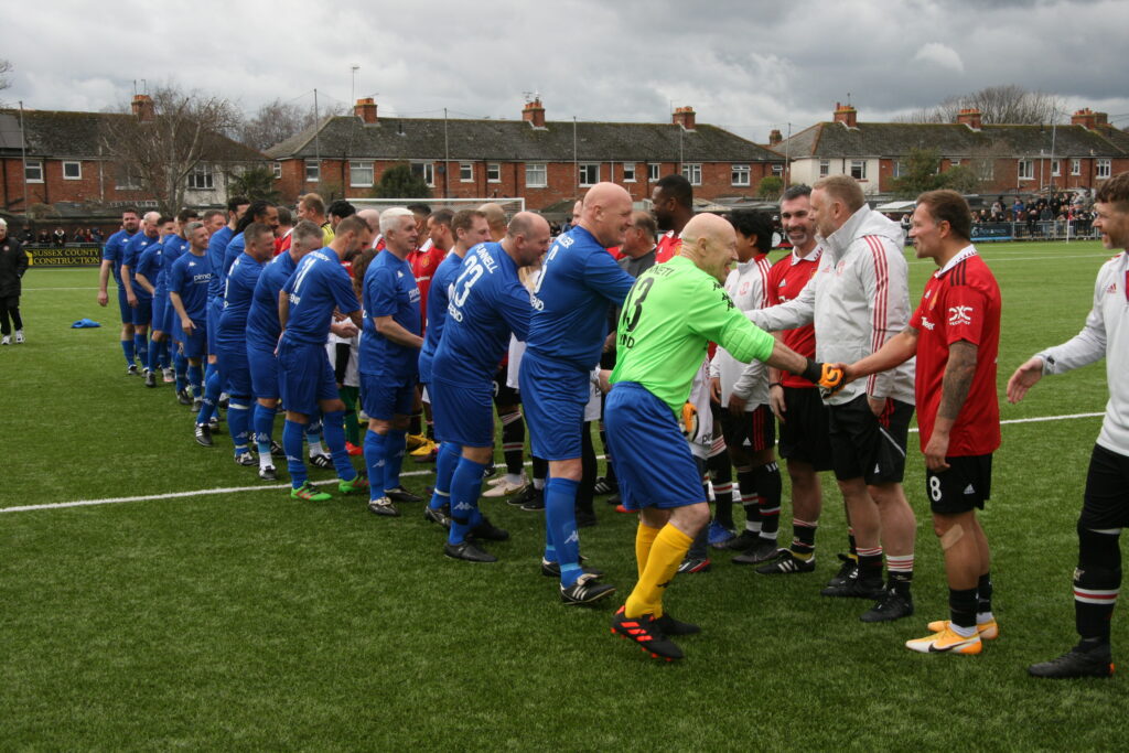Manchester United Legends shaking hands with Worthing Football Legends